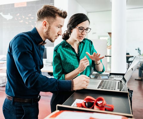 man and woman working on laptop